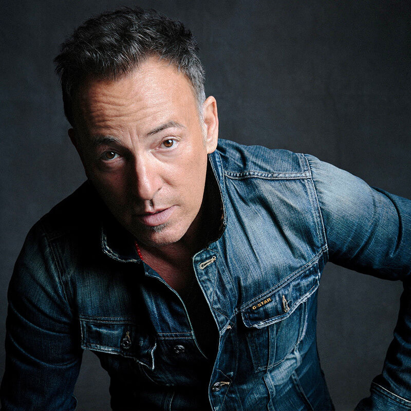A portrait of Bruce Springsteen in a jean jacket.