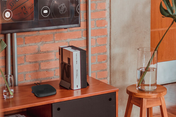 A small Roku player placed on a bookshelf.