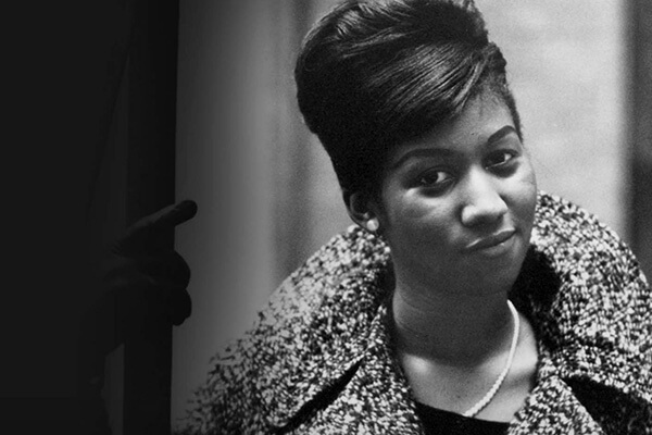 A classic black and white image of a young Aretha Franklin from the 1960s.