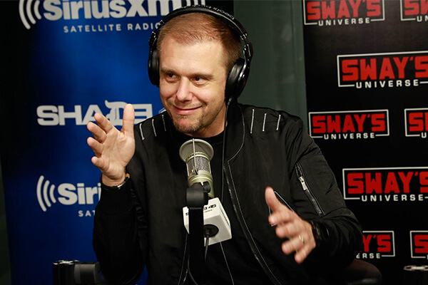 An image of Armin van Buuren sitting in front of a microphone.