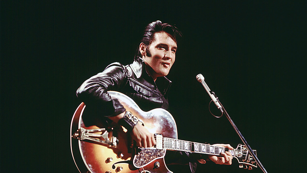 An image of Elvis Presley in leather with a guitar from the '68 Comeback Special.