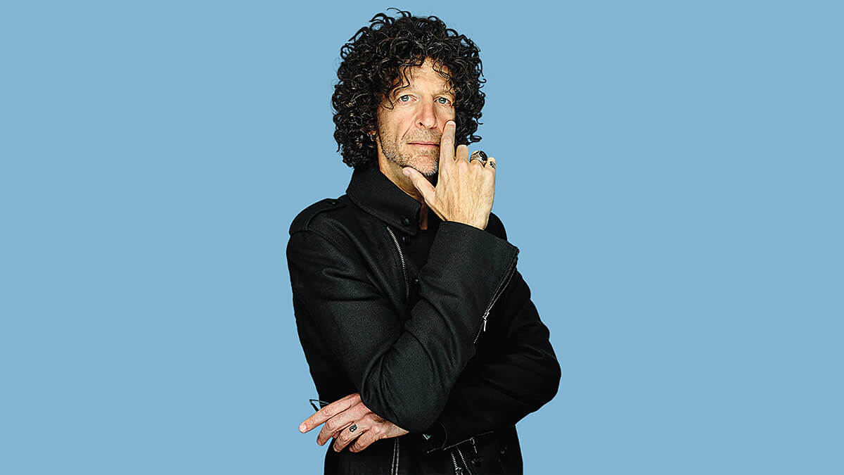 A thoughtful image of Howard Stern with his head resting in one of his hands.