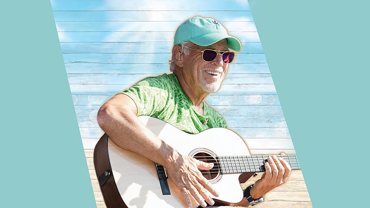 An image of Jimmy Buffet wearing a baseball hat and holding an acoustic guitar.