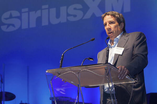 SiriusXM Canada's President and CEO Mark Redmond giving a presentation on stage.
