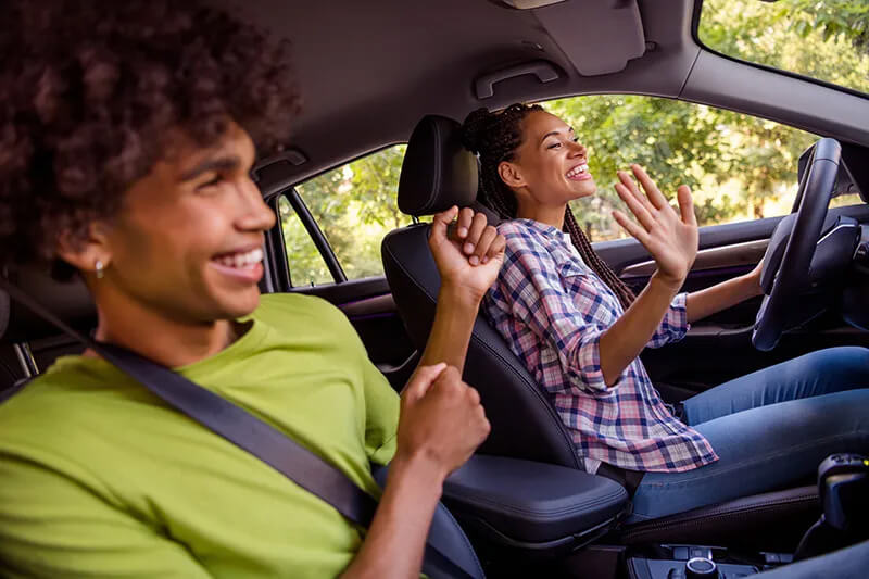A couple listening to SiriusXM while driving.