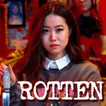 A young woman with long dark hair sits in a room with red lighting, holding a syringe. The word ROTTEN is written in bold white letters across the bottom of the image—Listen to the Rotten Mango podcast on SiriusXM.