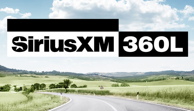 Une route rurale incurvée traverse des champs verts sous un ciel partiellement nuageux, avec un grand logo SiriusXM 360L bien en vue au centre de l'image.