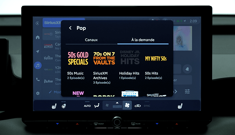 Un écran d'infodivertissement SiriusXM pour Toyota avec 360L affiche une application musicale ouverte sur une section de musique pop, avec des playlists telles que 50s Gold Specials, 70s on 7 from the Vaults, et My Nifty 50s sous des chaînes à la demande.