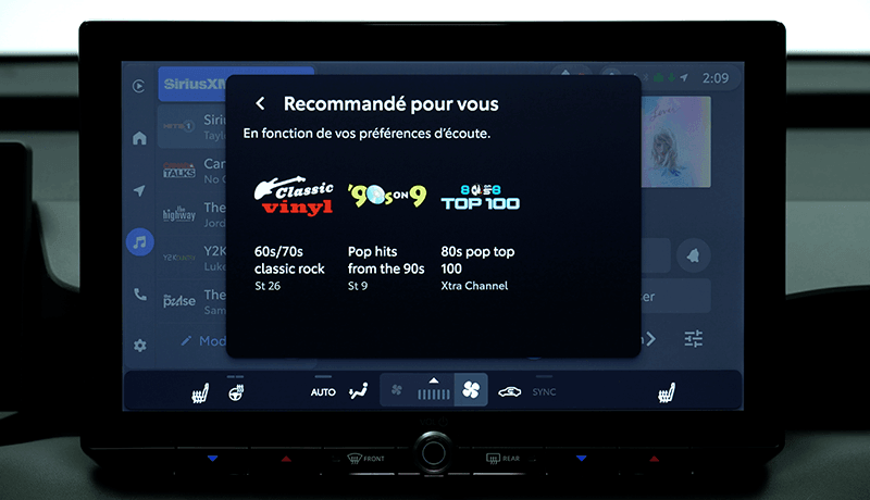 Un écran d'infodivertissement SiriusXM pour Toyota avec 360L affiche des recommandations musicales en français, avec Classic Vinyl pour le rock classique des années 60/70, 90s on 9 pour les tubes pop des années 90, et Top 100 pour le top 100 des années 80 et de la pop, chacun avec son numéro de chaîne respectif.