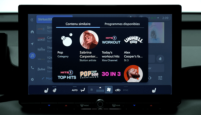 Un écran d'infodivertissement SiriusXM pour Toyota avec 360L affiche une application musicale suggérant des contenus similaires, notamment de la musique pop, Sabrina Carpenter et des tubes d'entraînement, avec des images d'artistes et des icônes de listes de lecture.