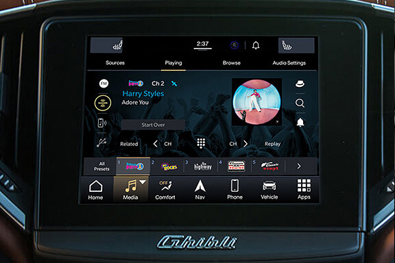 A SiriusXM infotainment screen for Maserati with 360L displays music playing on channel 2; the song is Adore You by Harry Styles. Various control and app icons appear below the album art, including home, media, comfort, navigation, phone, and vehicle.