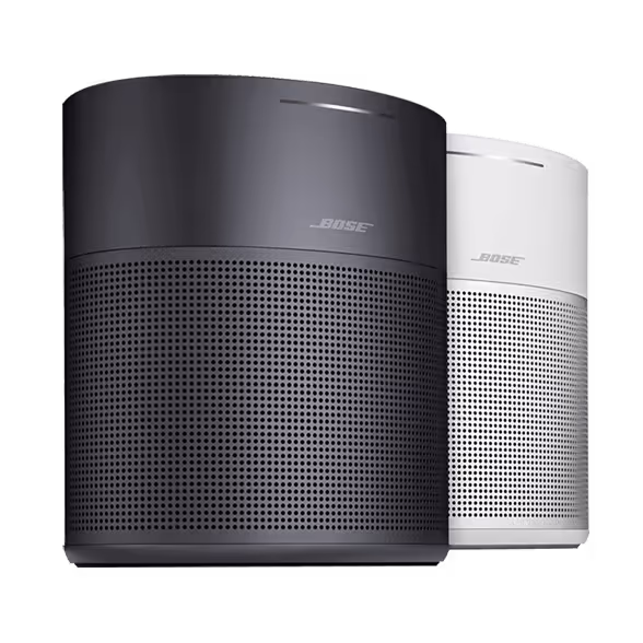 Two Bose smart speakers, one black and one white, are positioned side by side against a white background. Both have a modern design with a mesh grille on the lower half and the Bose logo near the top, seamlessly supporting the SiriusXM app for an enhanced listening experience.