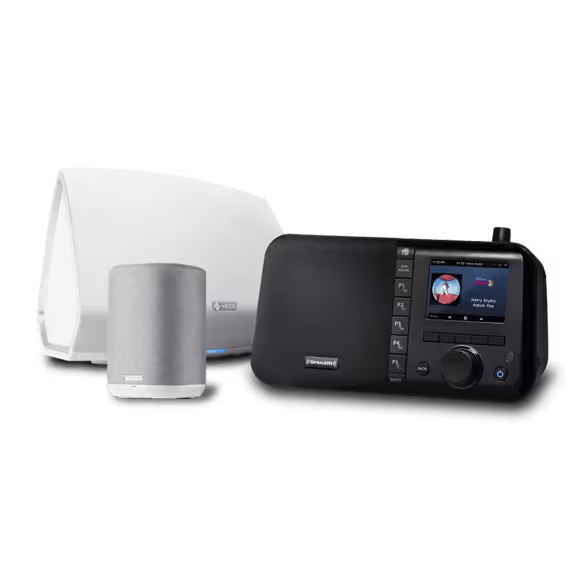 Three electronic devices are shown: a white speaker, a smaller speaker in grey, and a black digital radio with a screen and control buttons. These versatile devices can be connected and used to stream music through the SiriusXM app.