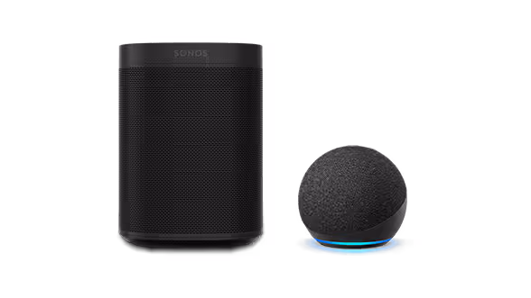 A Sonos smart speaker and an Amazon Echo Dot smart speaker, both black. The Echo Dot, powered by Amazon Alexa, features a glowing blue ring at its base.