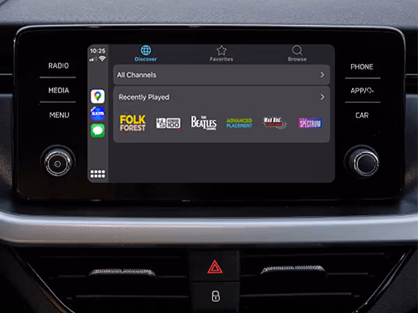 The SiriusXM CarPlay screen displays music and radio options such as Folk Forest, The Beatles, and others in a neatly organized interface. Seamless integration.