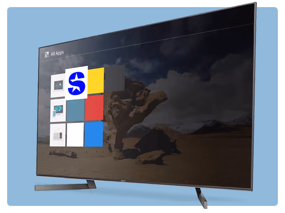 A flat-screen Sony TV displays an app menu with colourful tiles with SiriusXM selected over a desert landscape background. The TV stands on two legs, and the screen is angled slightly to the right.